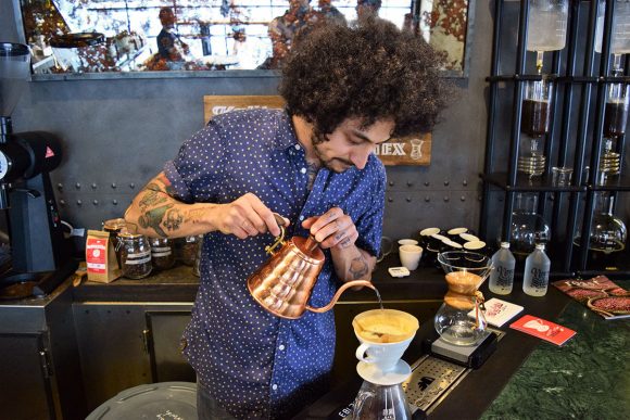 Barista infusionando café filtrado en la barra de All Saints Café Microcentro