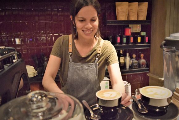 Barista de Shelter Coffee preparando un latte